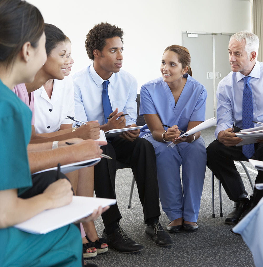 Mixed group of healthcare professionals sitting in a semi circle