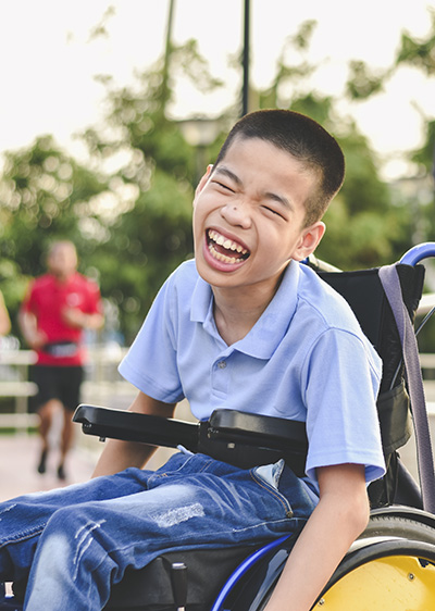 Boy with long-term illness in a wheelchair laughing