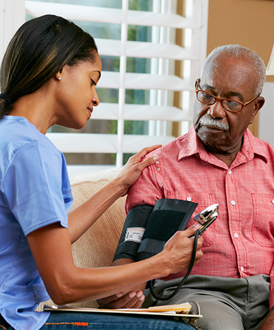Older man having his blood pressure checked by a nurse