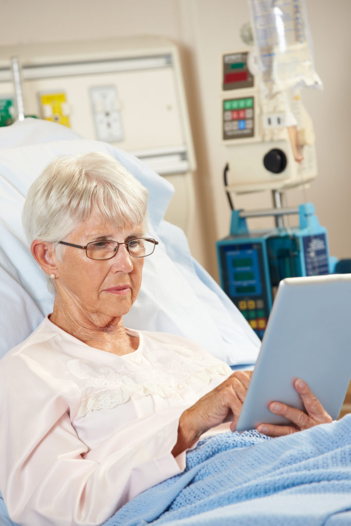 Female patient in a hospital bed with an iPad